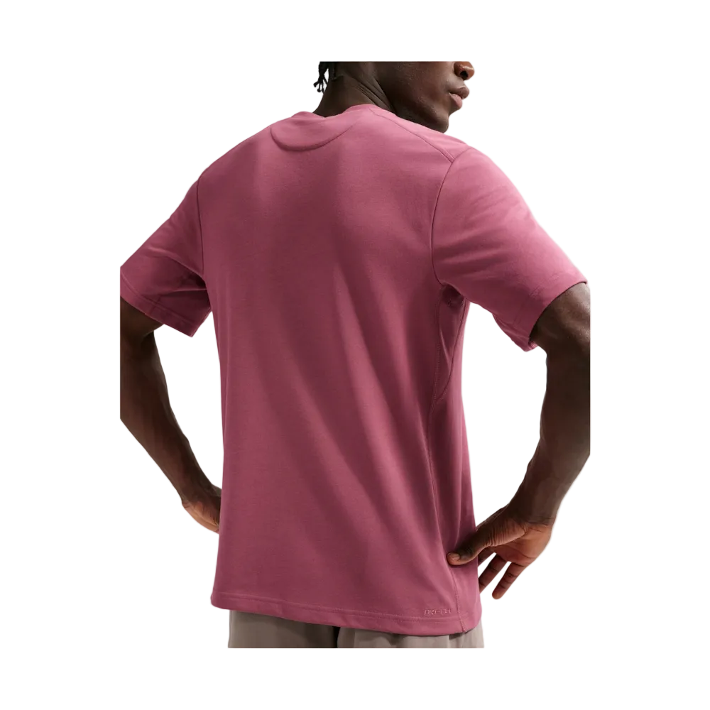 A man wearing a dusty rose short-sleeve t-shirt, shown from the back against a light gray background.