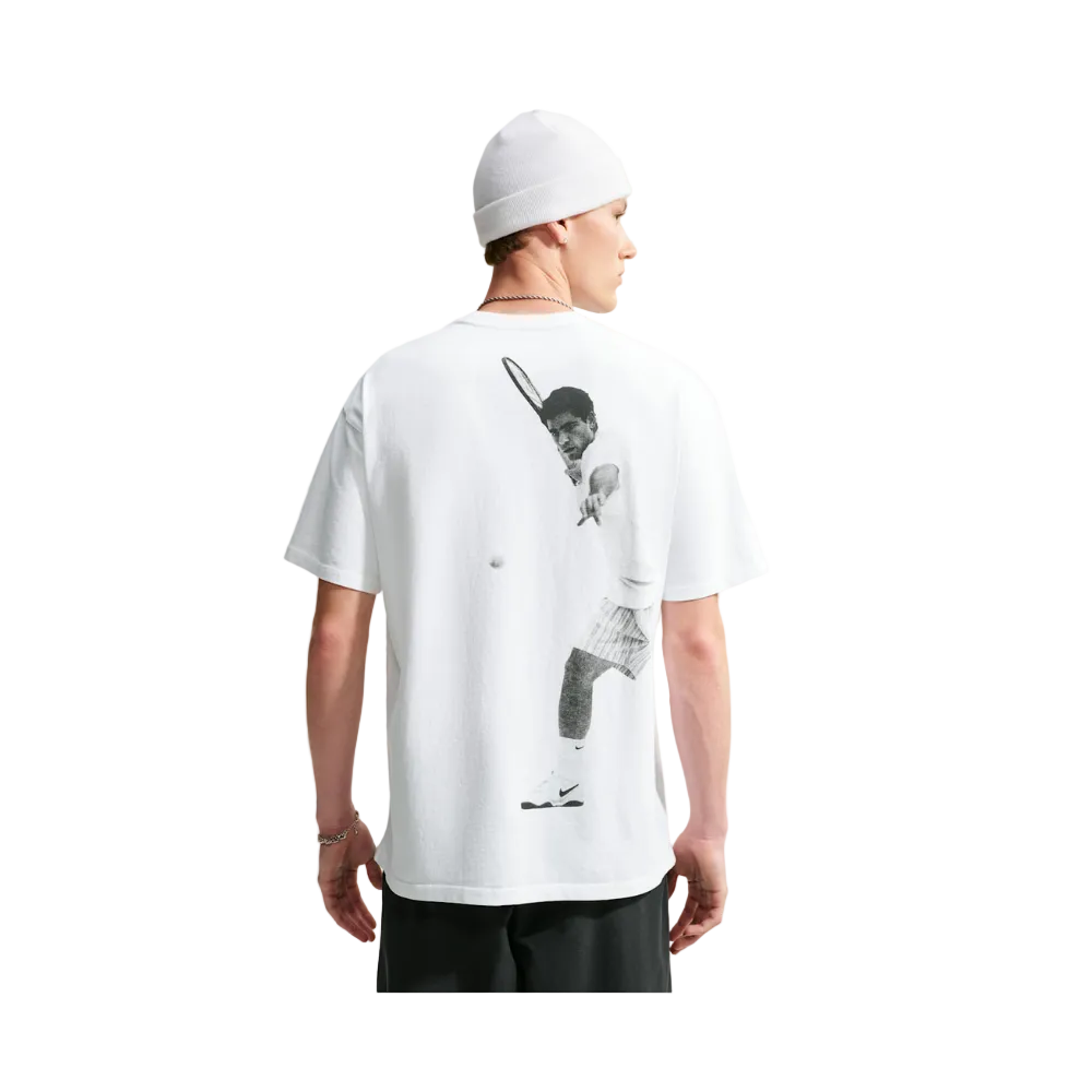 A man wearing a white t-shirt with a large black-and-white tennis player graphic on the back, shown from behind against a light gray background.